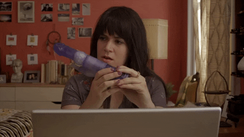 Abbi from Broad City looking at a vibrating sex toy thinking about masturbating.