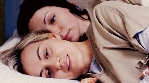 Orange is the New Black characters who are lesbian sexual partners kiss and cuddle in bed.
